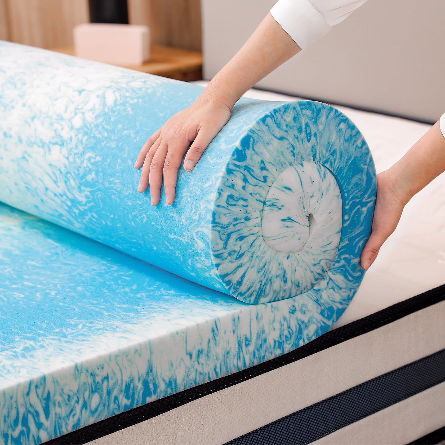 Gel-infused memory foam topper being unrolled onto a mattress